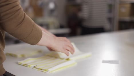 unrecognizable fashion designer or tailor working with fabric patterns at the studio, close up