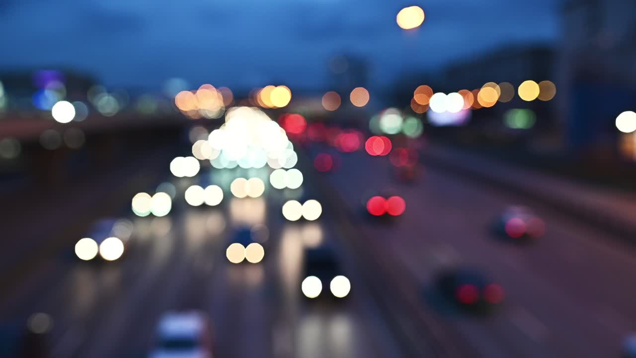 밤에는 자동차와 신호등의 보케, 시내의 밤 교통의 보케. 시내 거리의 교통체증에서 차의 신호등에서 빛나는 둥근 다채로운 보케.