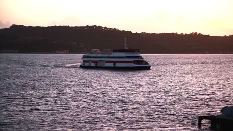 Fähre-Auf-Dem-Fluss-Tejo-Bei-Sonnenuntergang-Mit-Fabriken-Im-Hintergrund