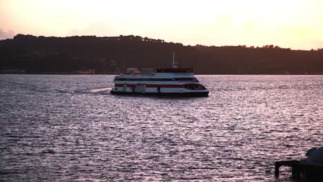 ferry boat on river tejo at sunset with factories in background