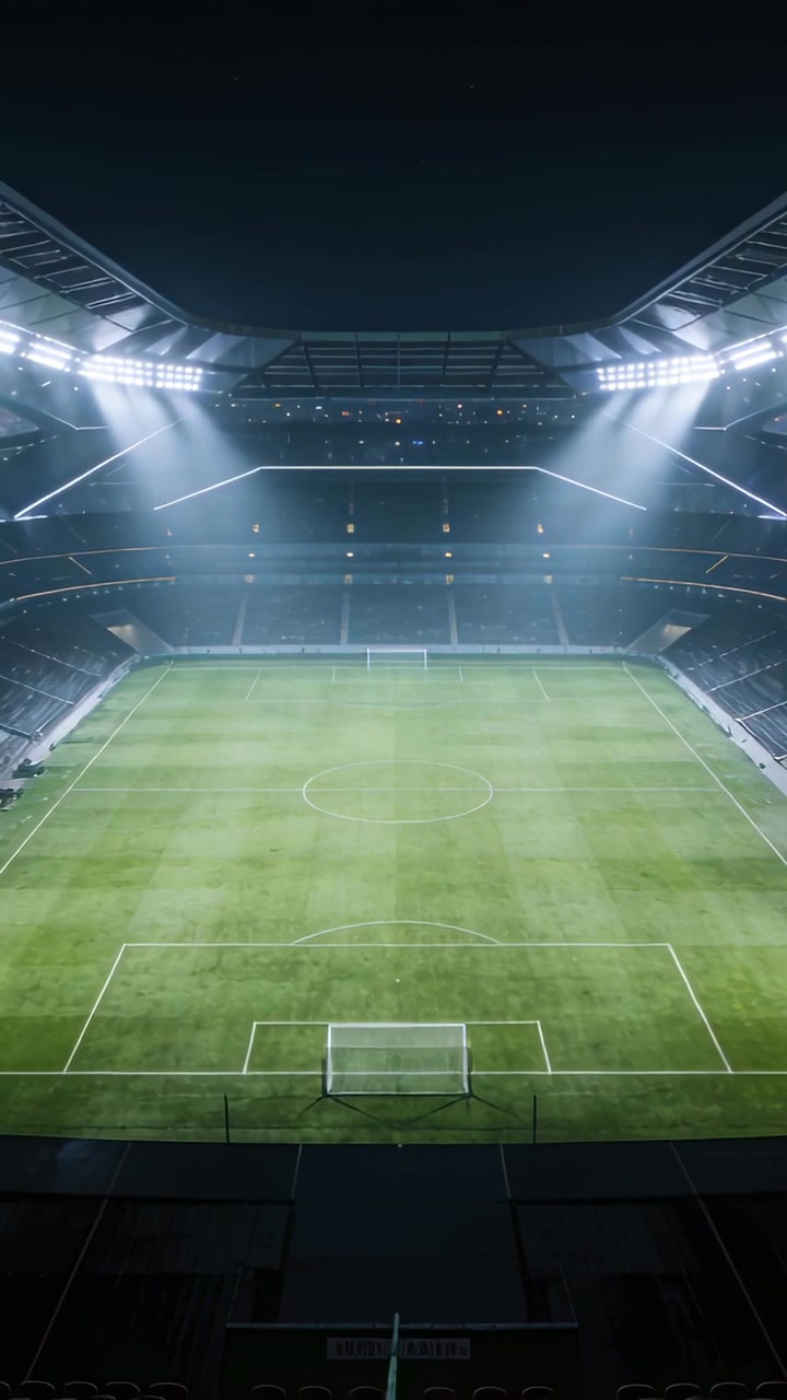 Video verticale: Telecamera che arretra mostrando il campo da calcio allo stadio, luci che illuminano la porta per la partita.