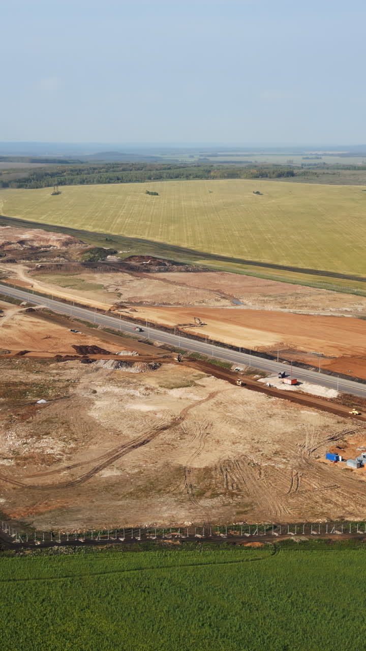 Aerial View of Highway Construction Site with Heavy Machinery and Rural Landscape