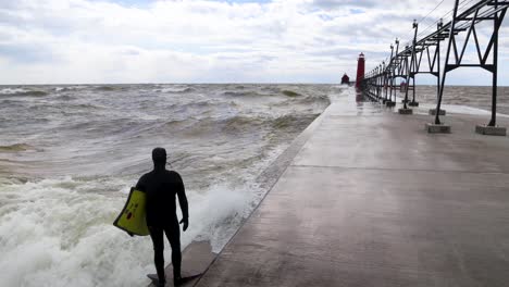 surfista buceando en el lago michigan desde el muelle en grand haven, michigan