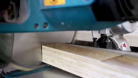 close-up of a miter saw cutting plywood