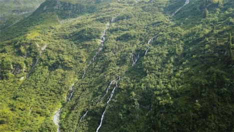 Disparo-De-Drones-Volando-Hacia-Con-La-Cámara-Inclinándose-Hacia-Abajo-Sobre-Un-Par-De-Cascadas-En-La-Ladera-De-Una-Montaña-En-Suiza-En-4k