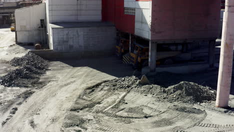 sitio industrial con camiones y pilas de grava
