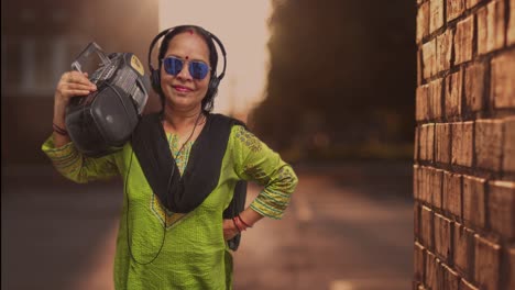 An-attractive-fashionably-stylish-lady-holding-a-Retro-Music-system-Jukebox-and-standing-in-Alley