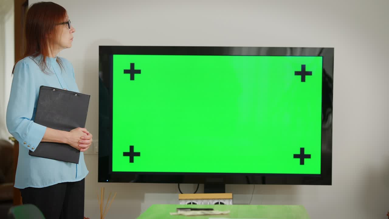 왼쪽에 서 있는 백인 여성과 함께 사무실에서 녹색 스크린 모니터를 사용합니다. chroma key 웹 컨퍼런스 실내에서 자신감 넘치는 지능형 관리자와 함께 프로젝트 계획 온라인 브레인 스토밍.