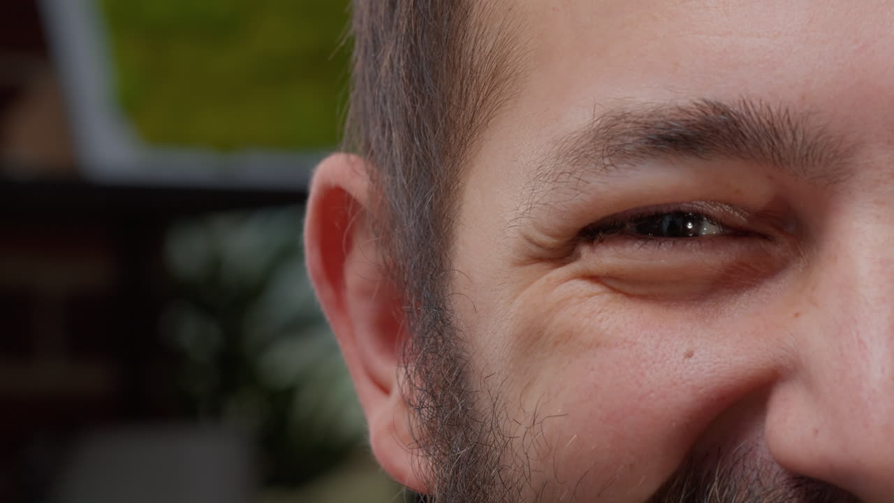 Macro shot of man showing one eye and half face on camera