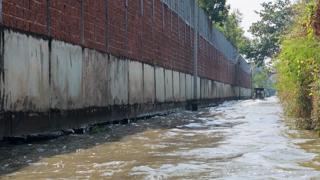 A 21-second video captures a boat navigating a polluted canal in Bangkok, showcasing urban decay and environmental challenges