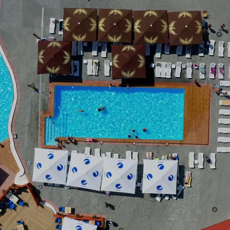 Aerial view on open swimming pool. Resort in rural locality. Modern territory with two open pools. Video from the top
