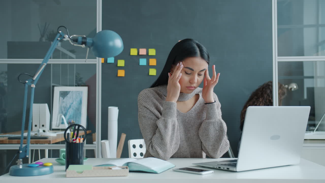 직장에서 두통을 고 있는 여성