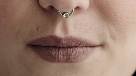 cerrar los labios de la mujer sonriendo feliz usando anillo en la nariz maquillaje cosméticos belleza femenina