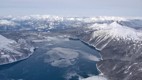 icy mountain lake on a bleak winter day high aerial view from airplane