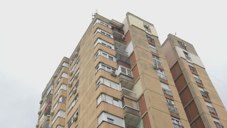 low angle view of tall residential building skyscraper, example of brutalist architecture, establishing shot