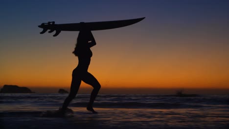 female surfer walking with surfboard in the beach 4k