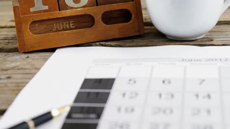 coffee cup with date block arranged on wooden plank