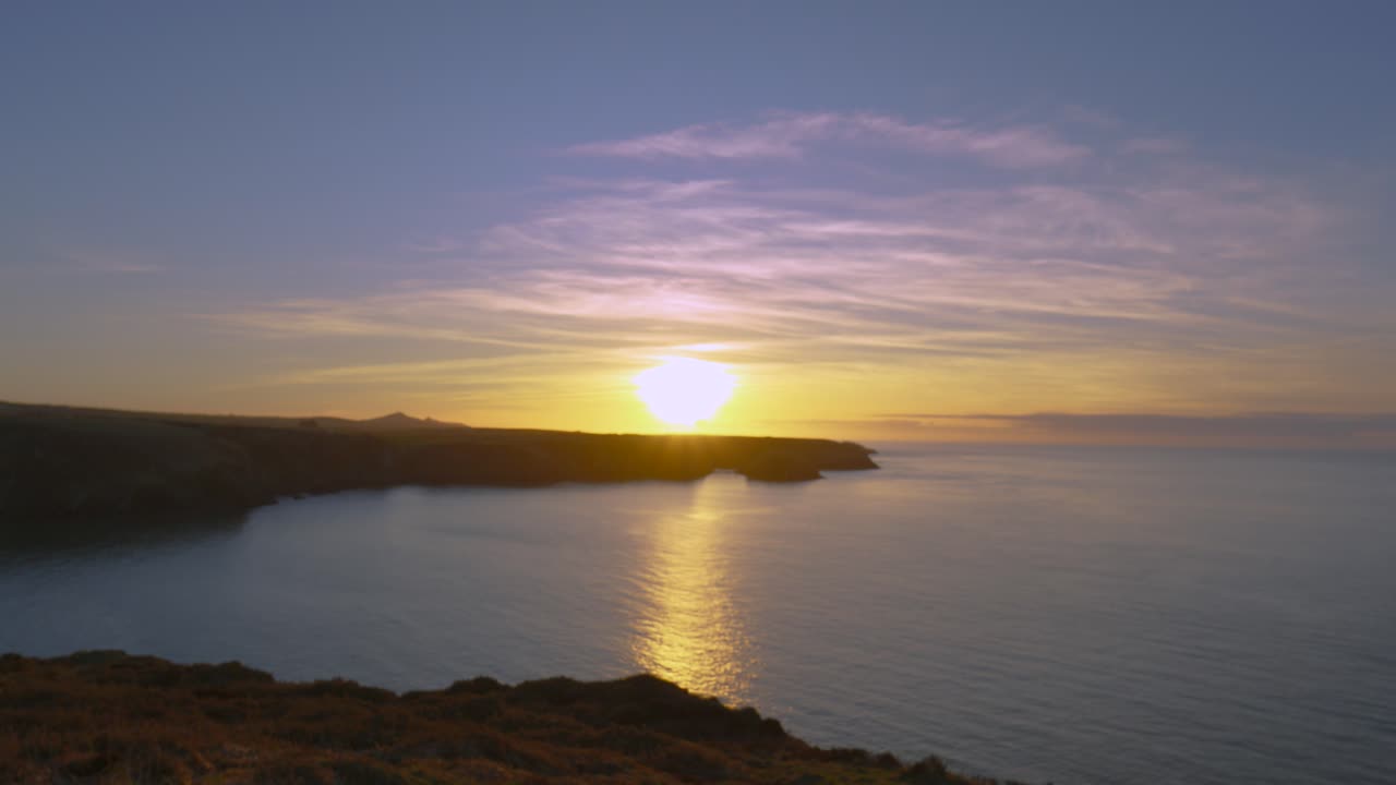 Sunset Timelapse Along Welsh Coastline in Pembrokeshire with Clouds and Sea Passing by with Reflection on Irish Sea Ocean. Wide Natural Landscape Hyperlapse 4K.