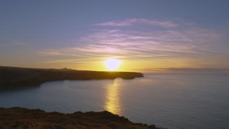 sunset timelapse along welsh coastline in pembrokeshire with clouds and sea passing by with reflection on irish sea ocean. wide natural landscape hyperlapse 4k.