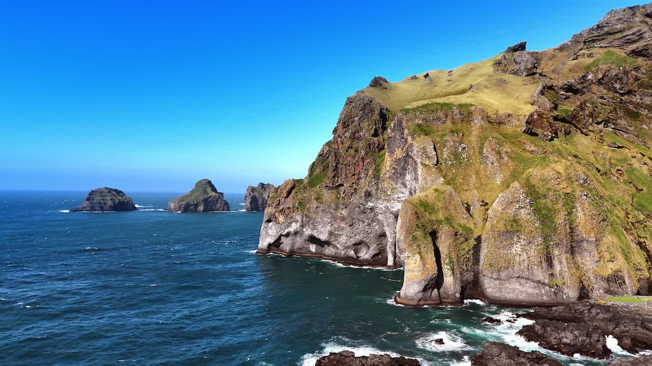 Rocks on the shore of the North Atlantic Ocean. Drone footage distancing from cliffs on the coast of Iceland.