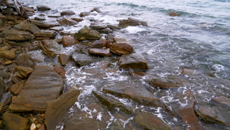 Slow-motion-scenic-landscape-of-nature-sea-wave-coast-to-beach-with-stone-and-rock-for-summer-vacation-concept