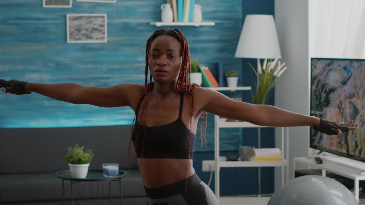 Slim athetic black woman wearing sportswear practicing leg stand posture