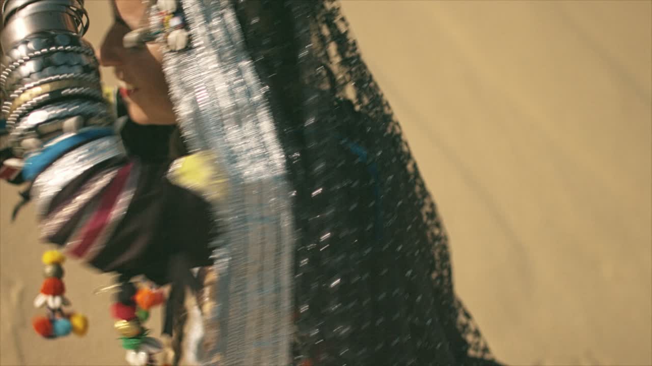 Donna Rom seduta che batte le mani nel deserto.