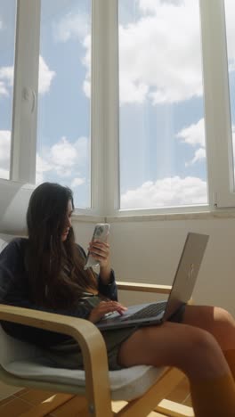 woman studying at home with laptop and phone