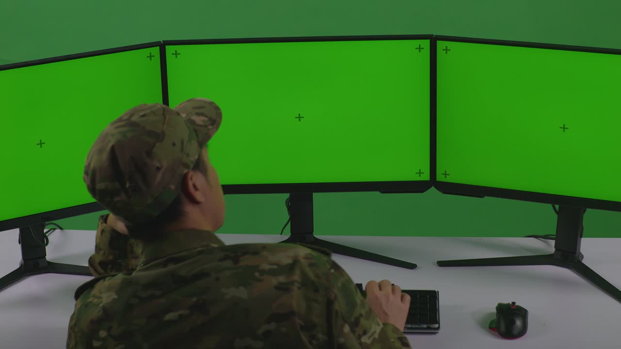 personal militar que trabaja en múltiples monitores en una sala de control