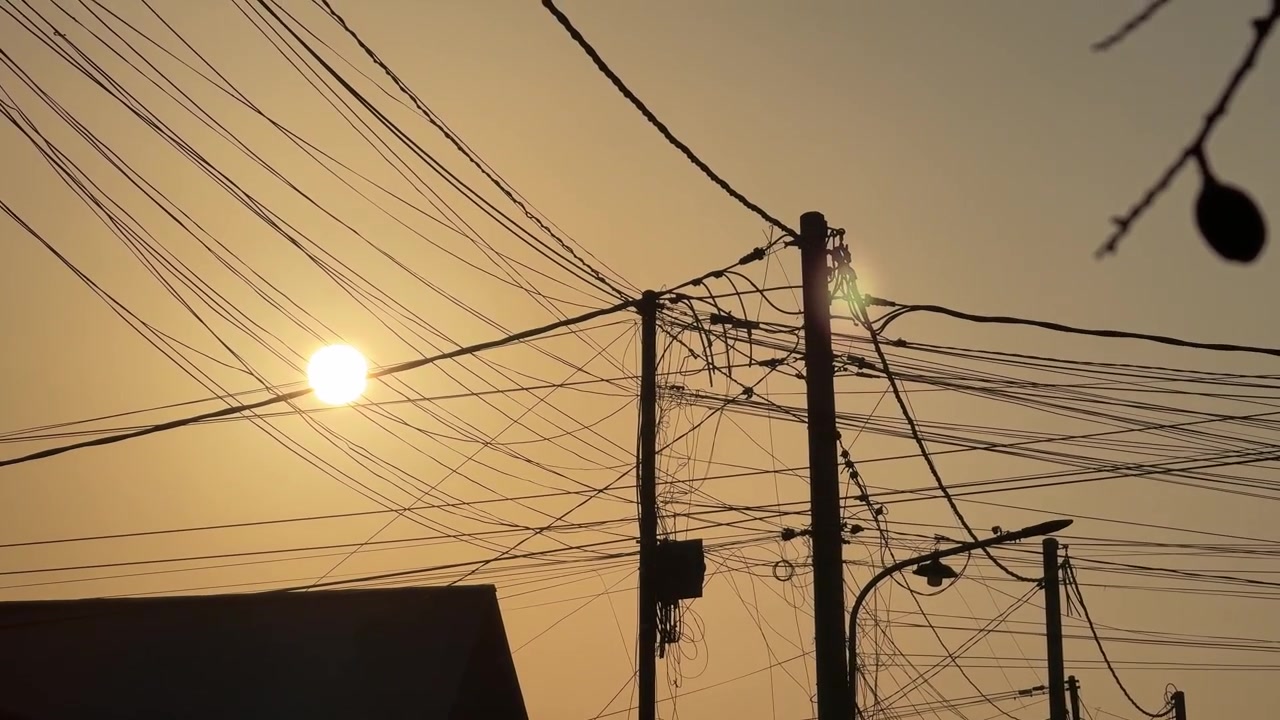 Sunset Behind Utility Poles and Tangled Power Lines