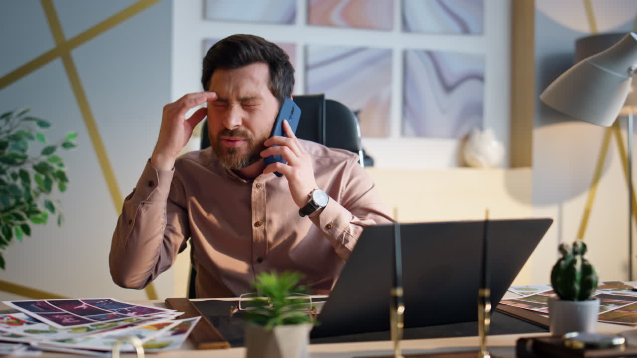 Nervous manager talking mobile phone gesturing emotionally at office close up.