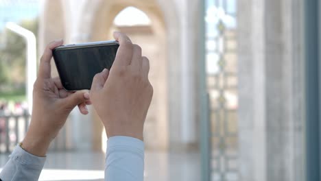 woman taking a picture of a mosque