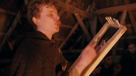 medieval musician playing harp by a fire