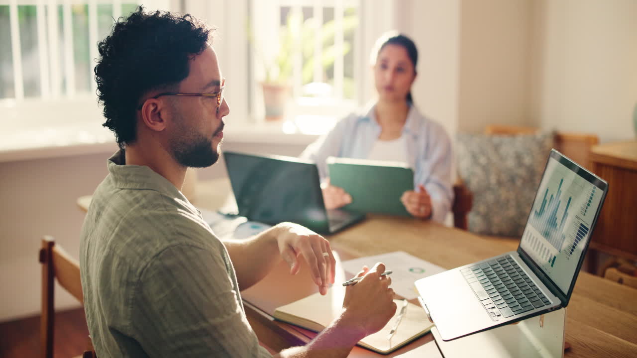 Due professionisti che discutono dati sui laptop