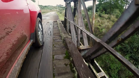 vista lateral del camión fangoso que cruza el puente de madera sobre el río