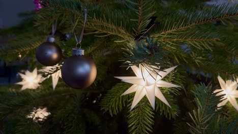 decoración de estrellas de iluminación en el árbol de navidad verde en casa, disparo de cerca. ornamento de estilo moderno y bolas. casa estadounidense en el vecindario.