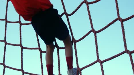 boy climbing a net during obstacle course training