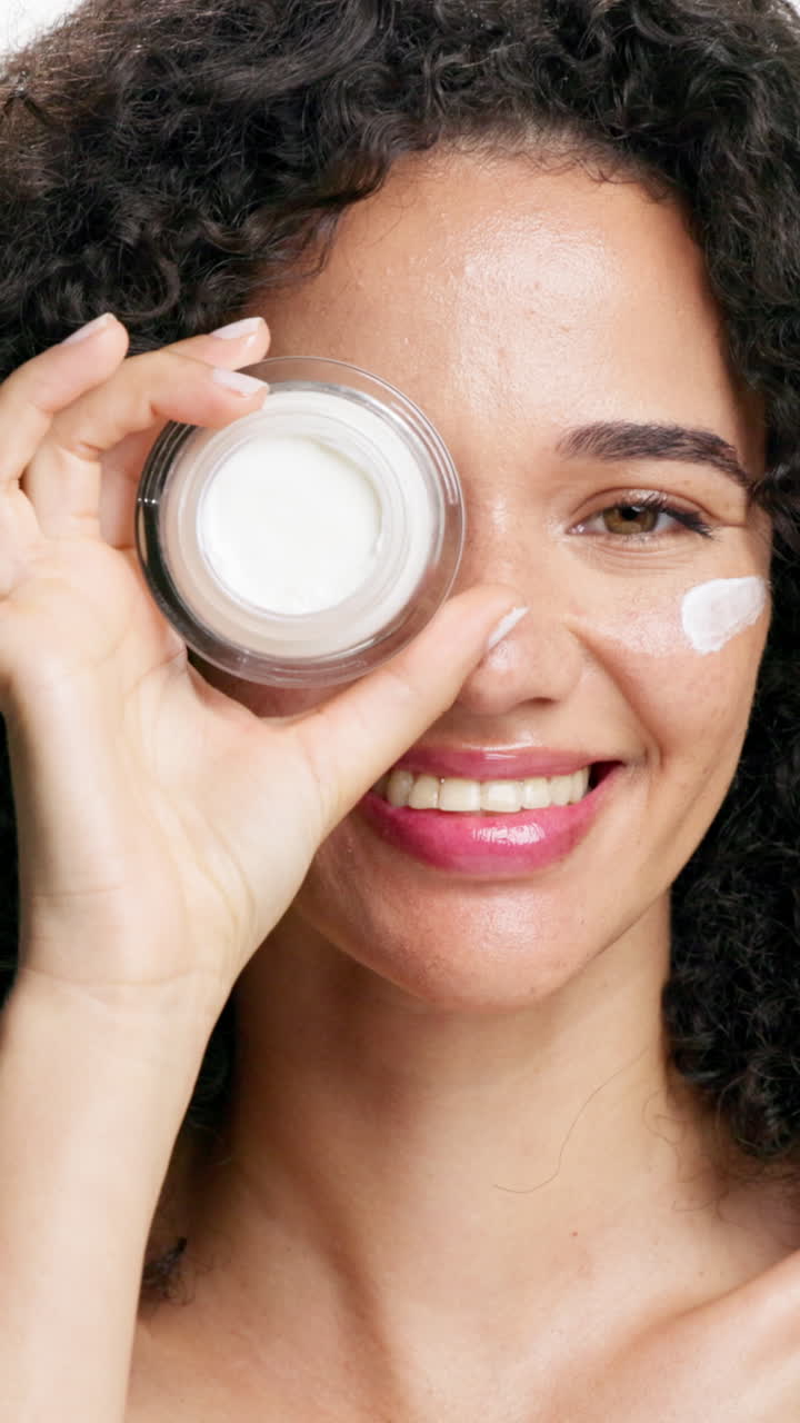 Mulher que aplica creme facial