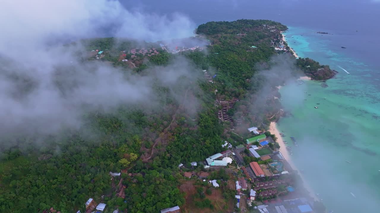 Awan pagi bergulir di atas pantai tropis Phi Phi, Thailand