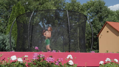 young teen boy enjoys trampoline jump in backyard