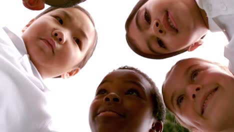 smiling children forming a huddle in circle