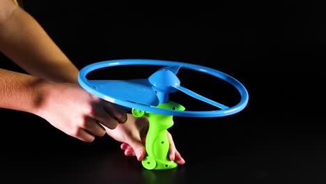 hands operate a pull string flying toy