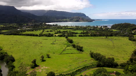 Panorámica-Aérea-Hacia-La-Bahía-De-Hanalei-Desde-La-Ladera-Cercana-En-Un-Día-Mayormente-Despejado.