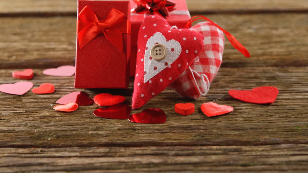 cajas de regalos y confeti en forma de corazón en una superficie de madera 4k
