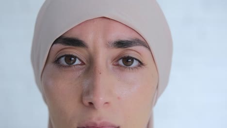 zoom en retrato de encantadora mujer musulmana en hijab beige, poderosos ojos atractivos mirando a la cámara. la mirada de ojos marrones con cejas negras, una mujer segura con un temperamento fuerte