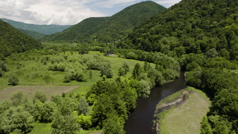 exuberante valle verde del río con árboles y colinas cerca de tkibuli, georgia