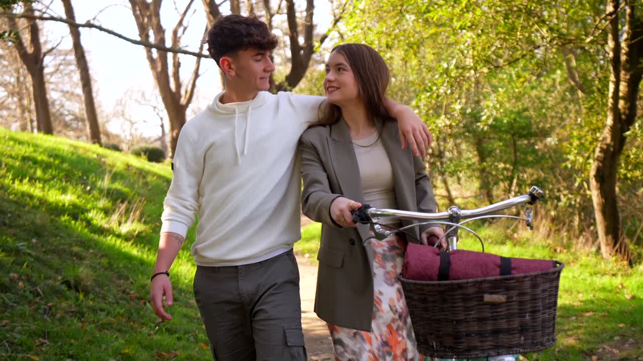 Young Couple Walking with Bicycle in a Park