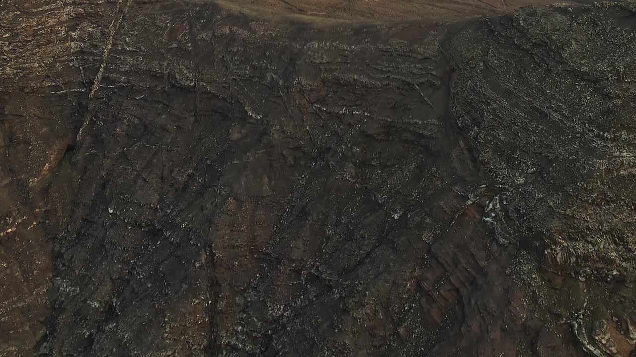 Texture di terreno vulcanico arido e piccoli arbusti
