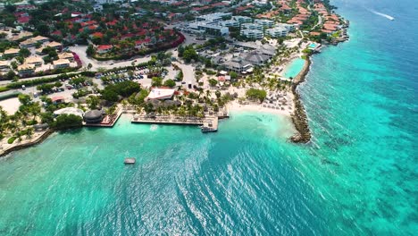 drone descends to clear turquoise caribbean waters by jan thiel and zanzibar beach, curacao