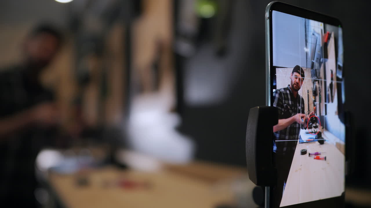 creador de contenido enseñando sobre equipo de cámara filmándose a sí mismo en un teléfono inteligente, seguimiento de disparo